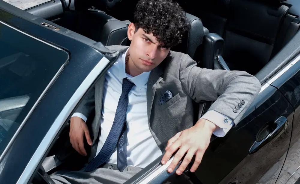A statement look featuring a tailored suit, a signature silk tie, and impeccable details